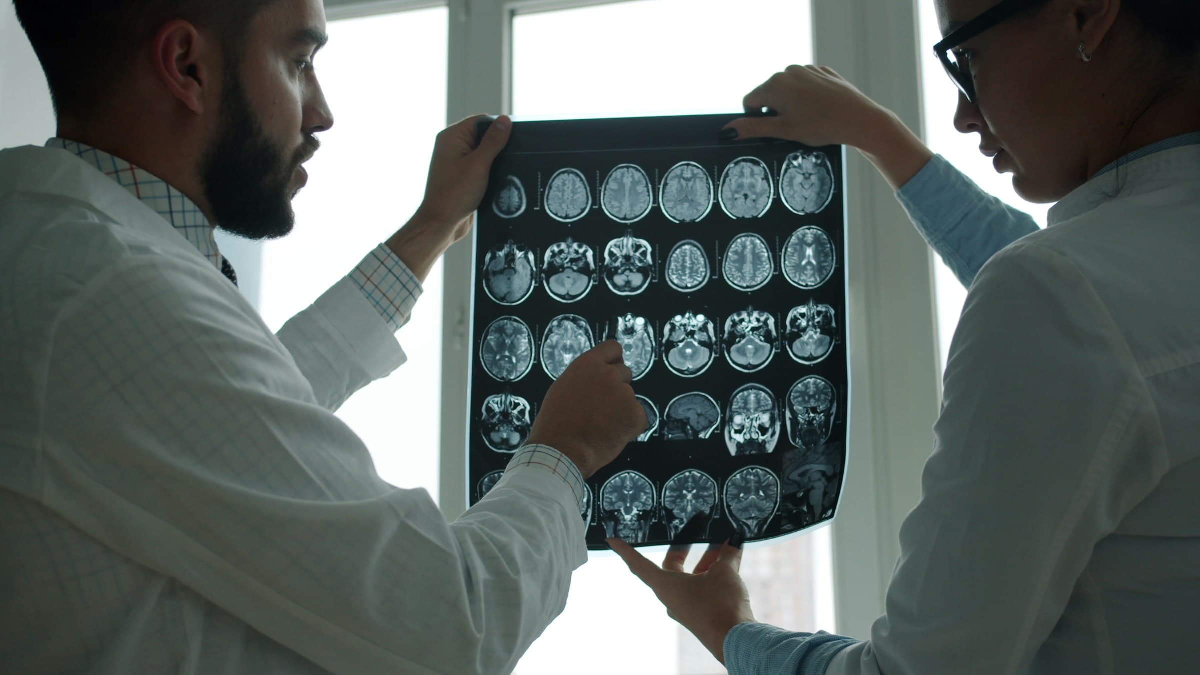 Twee artsen bespreken samen een reeks MRI-beelden